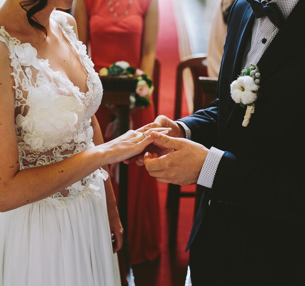 Groom wears the ring on the finger of the bride in the church