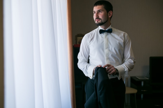 Free photo groom with bow tie getting ready for his wedding