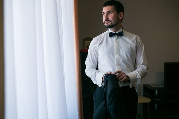 Groom with bow tie getting ready for his wedding