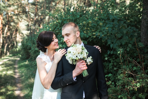 Groom with the bride and holding a beautiful bouquet