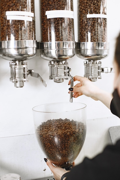 Not ground coffee. Black grains. Coffee in containers.