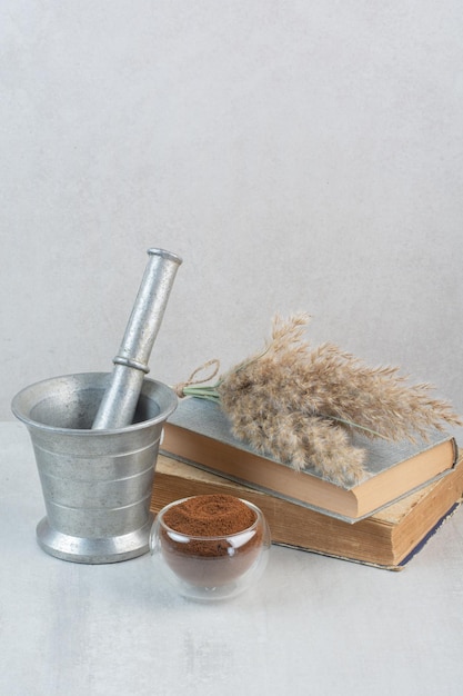 Free photo ground coffee, books and mortar and pestle on gray table. high quality photo