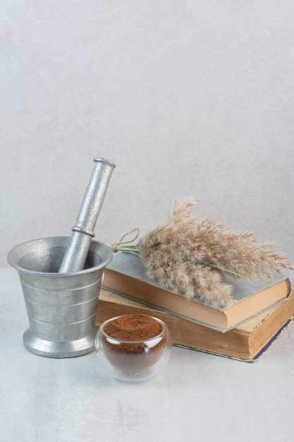 Caffè macinato, libri e mortaio e pestello sul tavolo grigio. foto di alta qualità