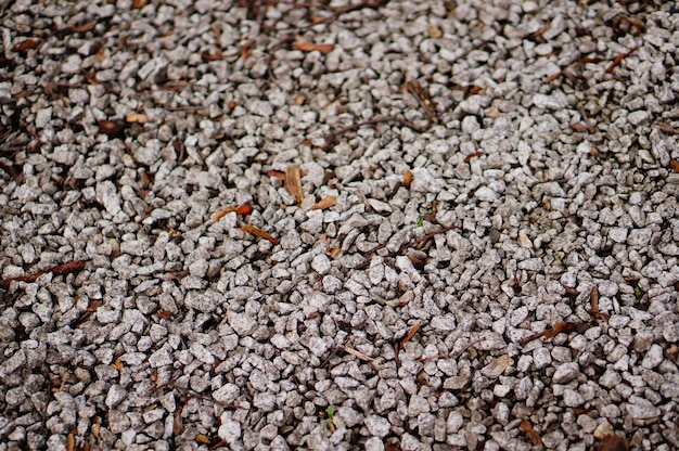 Ground covered in small stones under the sunlight with a blurry background