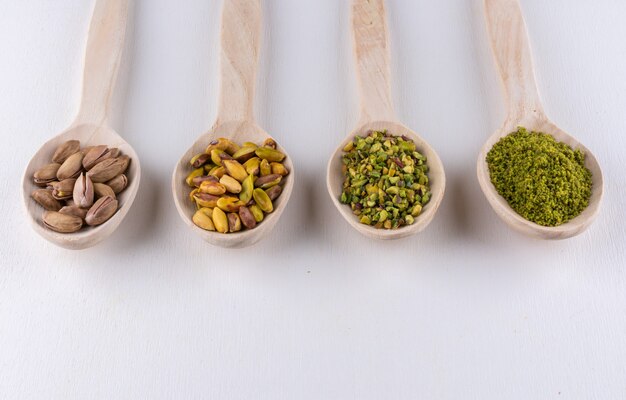 Ground, milled, crushed or granulated pistachios in wooden spoons