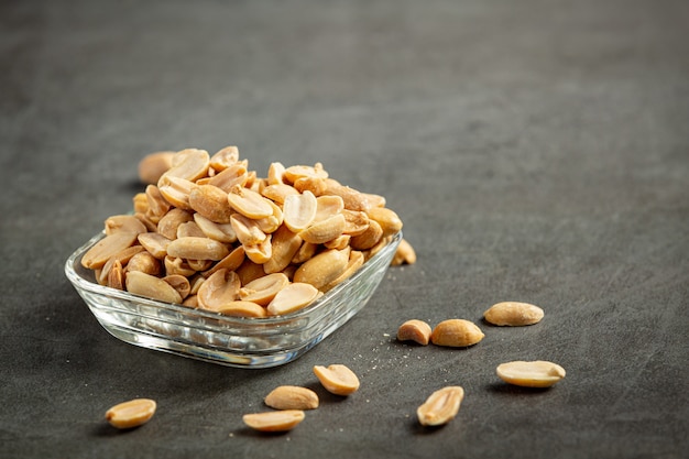Groundnuts put in glass plate on dark background