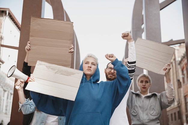 Group of activists giving slogans in a rally. Men and women marching together in a protest