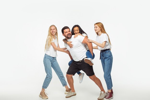 Group of adorable multiethnic friends having fun isolated over white studio background