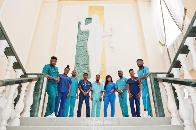 Группа африканских студентов-медиков в колледже, стоящих на лестнице