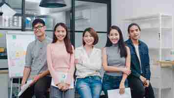 Free photo group of asia young creative people in smart casual wear looking at camera and smiling