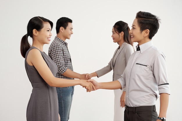 Group of Asian business people shaking hands in studio