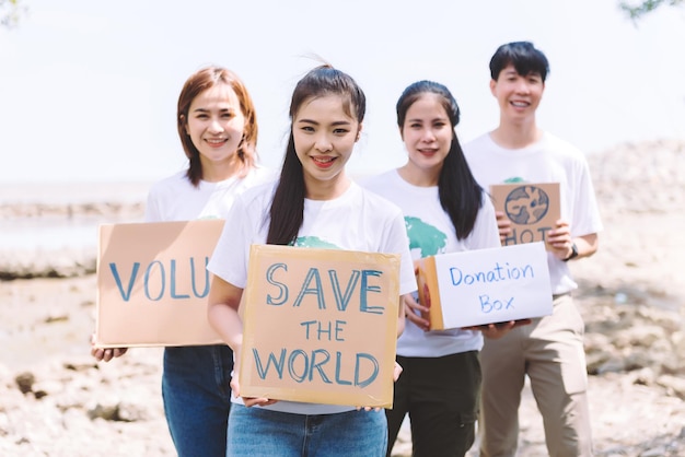 Группа азиатских разных людей добровольно держит речевой знак для кампании Всемирного дня окружающей среды День Земли о загрязнении, экосистеме, энергии и мусоре