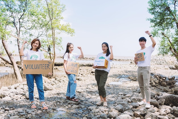 아시아의 다양한 사람들이 환경 오염 생태계 에너지와 쓰레기에 관한 세계 환경의 날 캠페인 지구의 날 연설 사인을 들고 자원 봉사합니다.