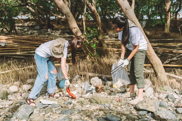 Group of asian diverse people volunteer teamwork environment conservationvolunteer help to picking plastic and foam garbage on park areaVolunteering world environment day