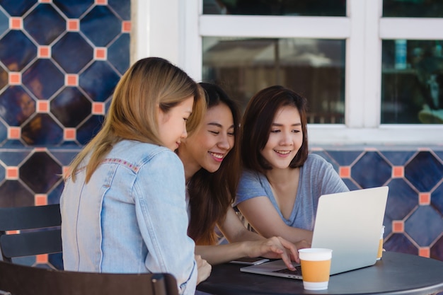 Group of beautiful smart business freelance Asian women in smart casual wear working together on lap