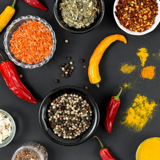 Group of bowls full of spices on black background