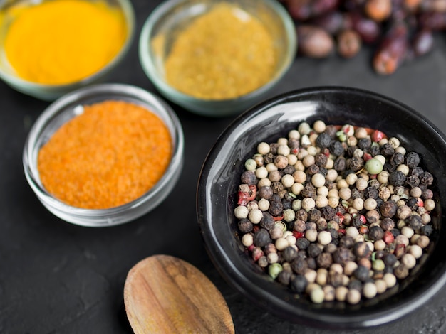 Free photo group of bowls full of spices on black background