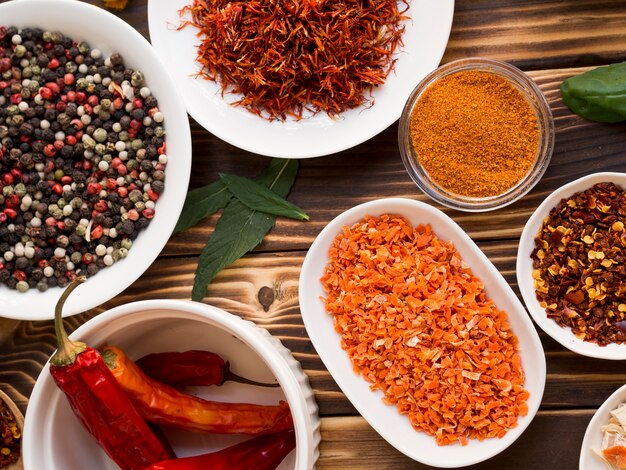 Group of bowls full of spices on wooden background