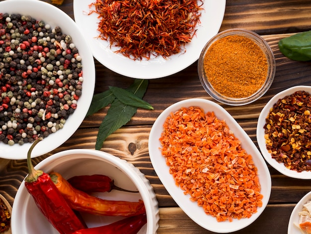 Group of bowls full of spices on wooden background