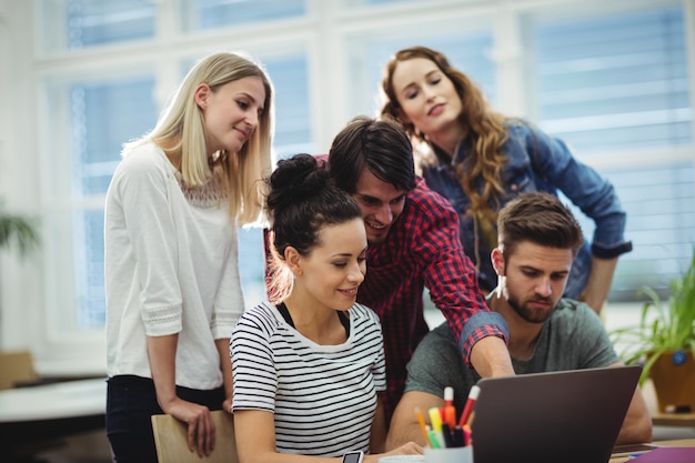 Foto gratuita gruppo di dirigenti aziendali discutere sopra il computer portatile al loro des