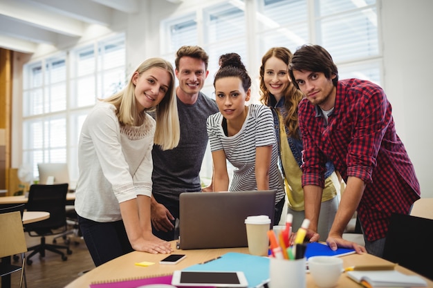 Group of business executives smiling at camera at their desk