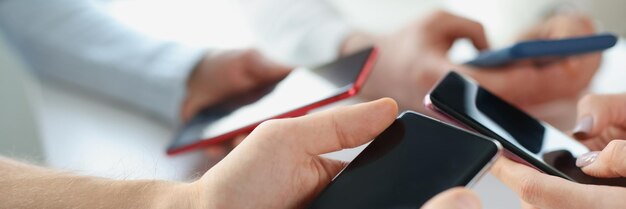 Group of business people holding a smartphone in their hands many mobile phones and addicted