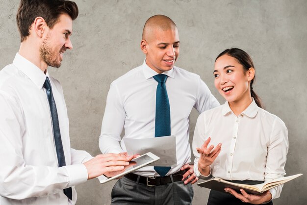 Group of business people sharing their ideas against concrete wall