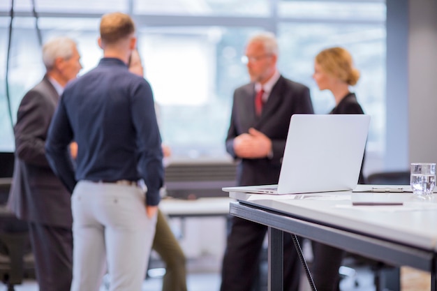 Free photo group of business people standing in front of laptop on table