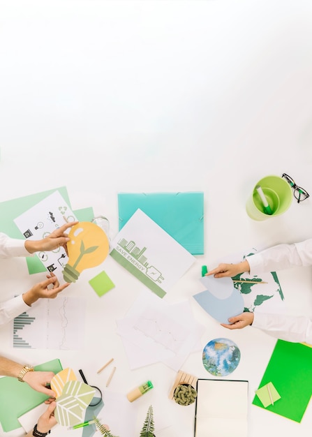 Group of businesspeople holding energy saving icons over desk