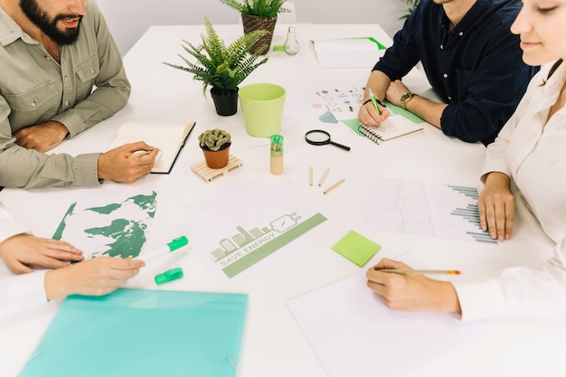 Group of businesspeople making strategy over energy saving in office