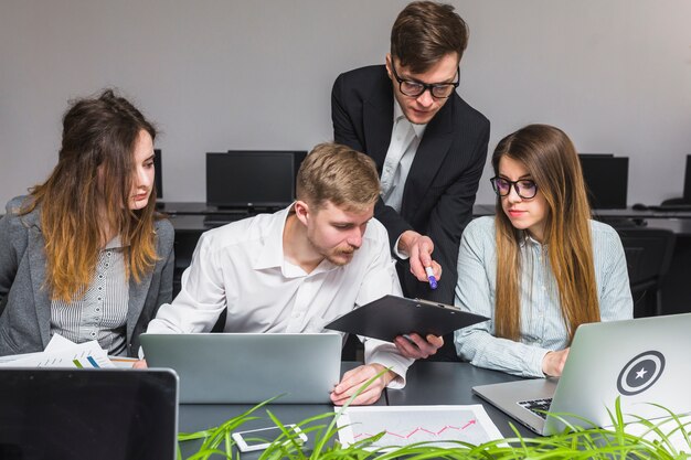 Group of businesspeople using laptop while working on document