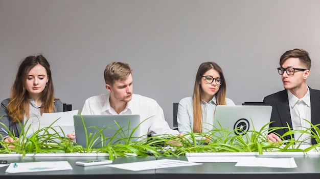 Group of businesspeople using laptop at workplace