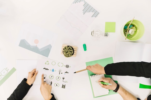 Group of businesspeople working on paper with energy saving icons