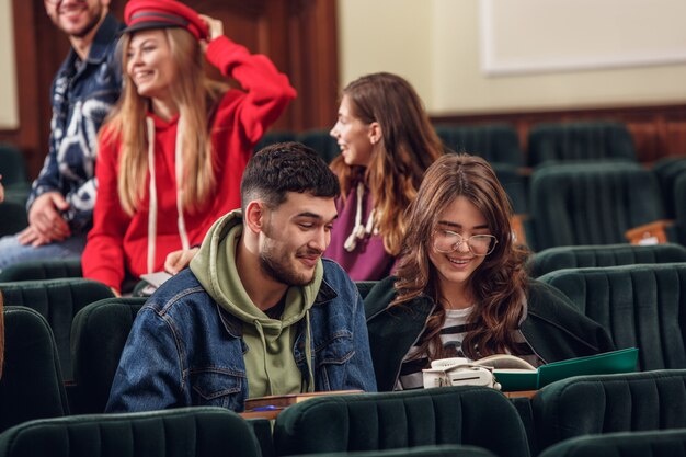 The group of cheerful happy students sitting in a lecture hall before lesson