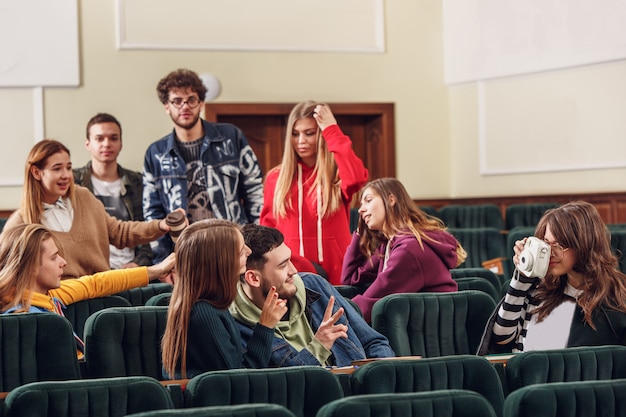 Free photo the group of cheerful students sitting in a lecture hall before lesson.