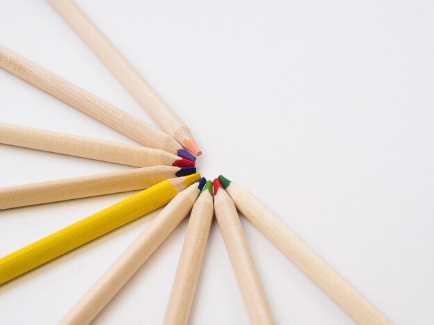 Group of colorful wooden pencils and one yellow pencil