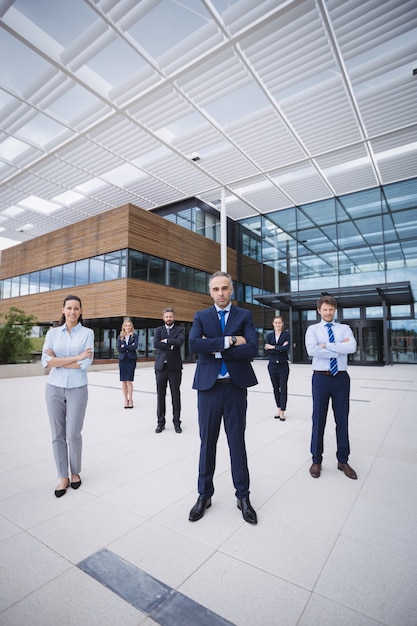 Group of confident businesspeople standing outside office building