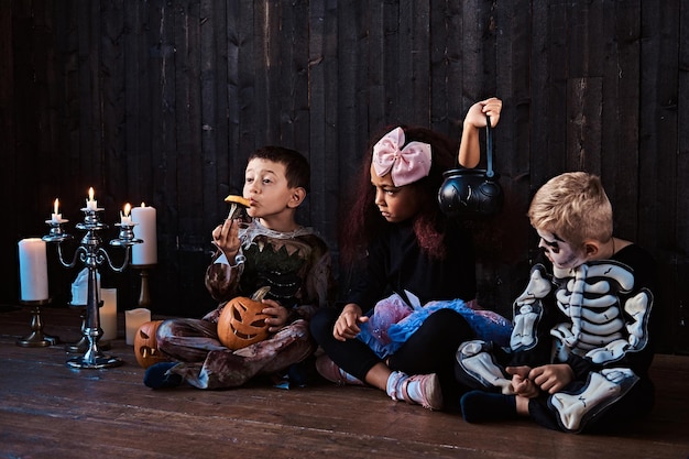 Group of cute multiracial kids in scary costumes during Halloween party in an old house. Halloween concept.