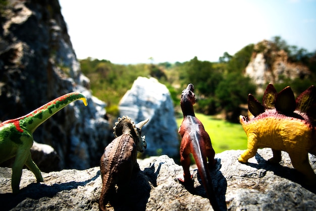 Free photo group of dinosaur toys on a rock