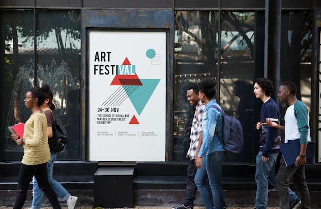 Group of diverse friends walking pass art exhibition placard