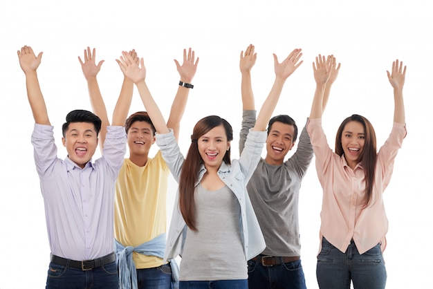 Group of excited casually dressed men and women posing with hands up