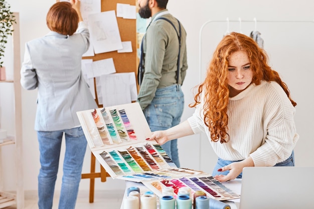 Gruppo di stilisti che lavorano in atelier con tavola delle idee e tavolozza dei colori