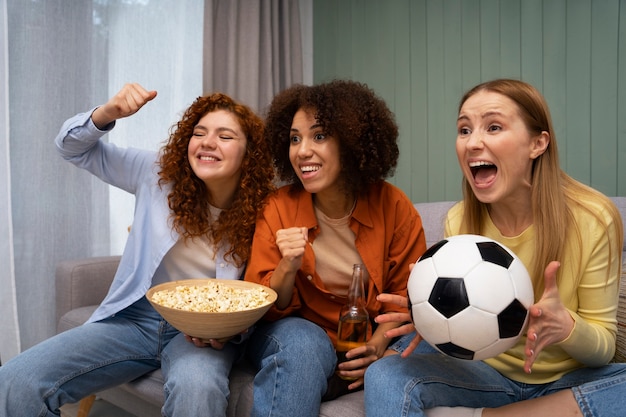 Free photo group of female friends at home watching sports together