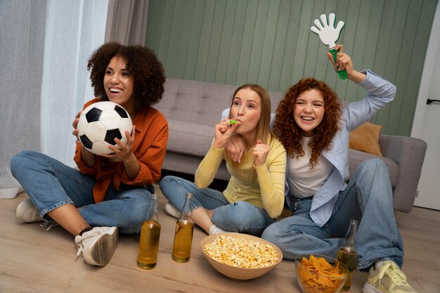 Free photo group of female friends and sports fans watching tv at home together