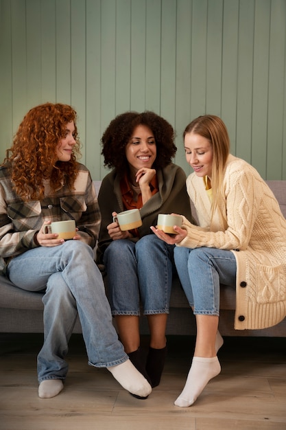 Group of female friends watching sports at home and having a drink