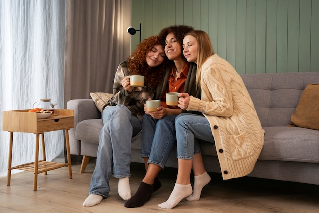 Group of female friends watching sports at home and having a drink