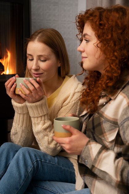 家でスポーツを見たり、飲み物を飲んだりする女友達のグループ