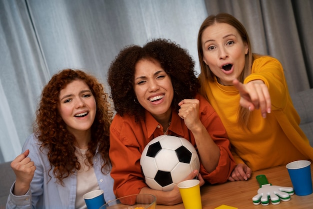 一緒に家でスポーツを見ている女性の友人のグループ