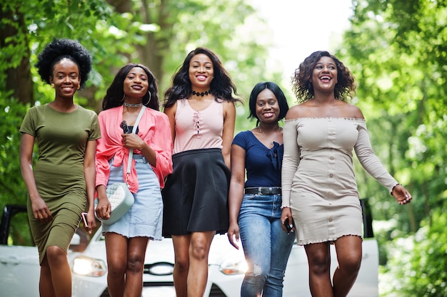 흰색 차에 기대어 걷는 5명의 행복한 아프리카계 미국인 그룹