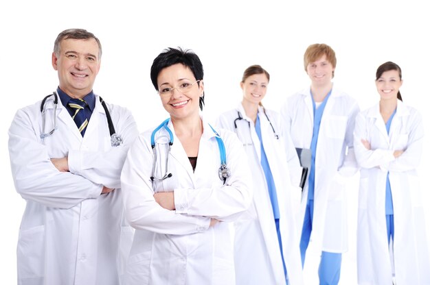 Группа пяти счастливых улыбающихся веселых врачей в больничных халатах
